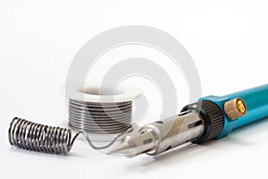 Tin solder and a soldering iron on gas on a white background