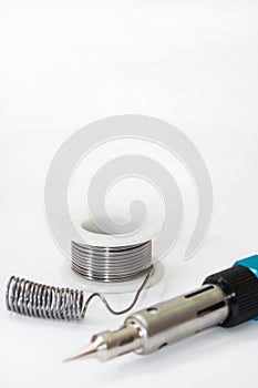 Tin solder and a soldering iron on gas on a white background