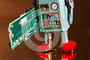 Tin toy robot carries computer circuit board, artificial intelligence concept