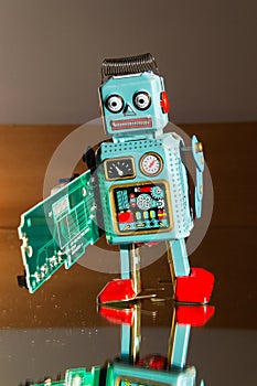 Tin toy robot carries computer circuit board, artificial intelligence concept