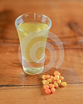 Tincture alcoholic in small shot glasses. Natural fruit alcohol drinks, shots served on a wooden table.