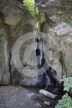 hidden waterfall between rough tall rocks photo