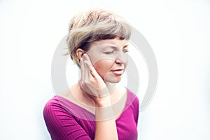 Tinnitus. Closeup up side profile sick female having ear pain to