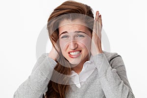 Tinnitus concept, nervous 20s woman suffering from headache grinding teeth photo