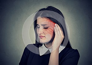 Tinnitus. Sick woman having ear pain colored in red head photo