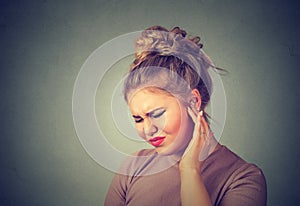 Tinnitus. Sick woman having ear pain touching her painful head photo