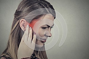 Tinnitus. Sick young woman having ear pain photo