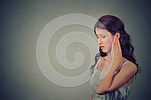 Tinnitus. Side profile sick young woman having ear pain touching her painful head photo