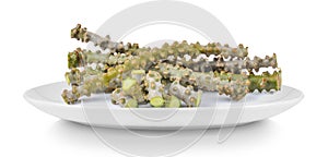 Tinospora cordifolia herb in plate isolated on white background