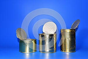 Tinplate silver food tin can on a blue background. Empty metal cans. The concept of reuse, disposal and recycling of garbage and