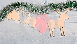 Tinsel with christmas ornaments and blank paper note wooden background. Merry christmas concept. Christmas ornaments and