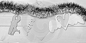 Tinsel with christmas ornaments and blank paper note wooden background. Merry christmas concept. Christmas ornaments and