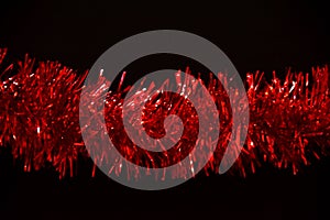 Tinsel. Red glitter on black background