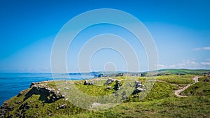 Rocky green landscape at Tintagel castle in Cornwall, England with the Atlantic Ocean coastline