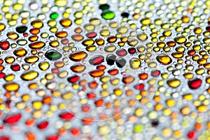 Tiny abstract colorful water drops on metal