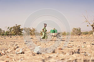 Tiny African Ethnicity Schoolgirl Engaged with nutritious Water for a lack of water symbol