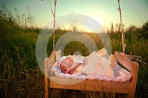 Tiny baby asleep in his crib in lace bonnet