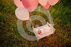 Tiny baby asleep in his crib in lace bonnet A in in cap and flies away with balloons