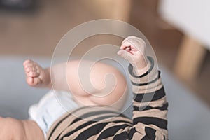 Tiny baby hand and leg close up still on an indoor home scene