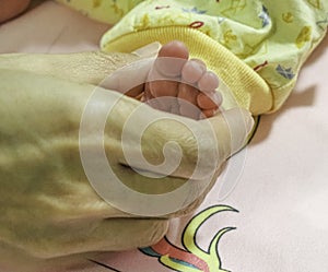 Tiny baby leg on women hand. Touch of love