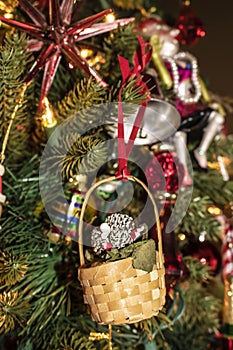 Tiny basket and pinecones retro vintage Christmas ornament on old fashioned tree - Selective focus