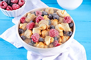 Tiny breakfast croissant cereals with fresh berries and milk