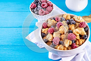 Tiny breakfast croissant cereals with fresh berries and milk