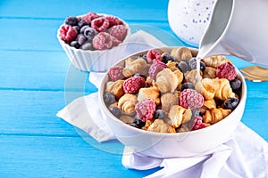 Tiny breakfast croissant cereals with fresh berries and milk