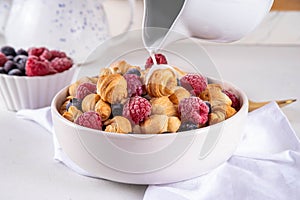 Tiny breakfast croissant cereals with fresh berries and milk