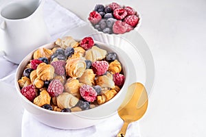 Tiny breakfast croissant cereals with fresh berries and milk