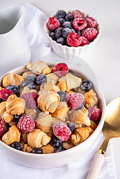 Tiny breakfast croissant cereals with fresh berries and milk