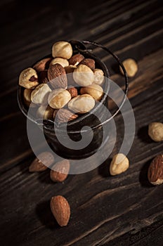 Tiny bucket of assorted nuts on a wooden background