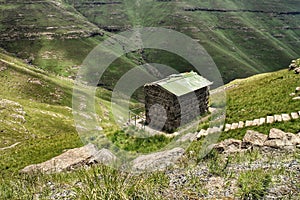 A tiny building next to a steep abyss in the Drakensberg mountains of Lesotho and South Africa.