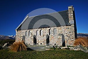 Tiny charming stone house with sloped roof and buttresses in wilderness