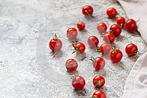 Tiny cherry tomatoes ciliegini, pachino, cocktail. group of cherry tomatoes on a gray concrete background. ripe and juicy cherry