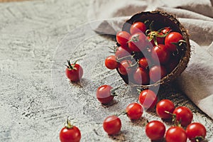 Tiny cherry tomatoes ciliegini, pachino, cocktail. group of cherry tomatoes on a gray concrete background. ripe and juicy cherry