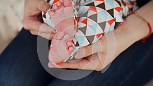 Tiny cute newborn baby foot in female hands