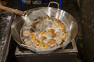 Tiny donuts being cooked at outdoor night street market