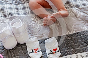 Tiny foot of newborn baby in soft selective focus near socks and droplets