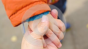 A tiny hand was gripping her mother's hand closeup