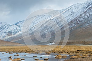 Tiny house, enormous mountain and pond in foregruond