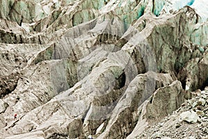 Tiny man walks expansive alpine glacier icefield