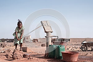 Tiny Native African Schoolgirl Bringing Tap Water in an arid zone