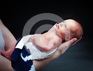 Newborn baby boy on the father`s hand.