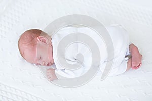 Tiny newborn baby boy sleeping on his tummy