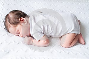 Tiny newborn baby sleeping on knitted blanket