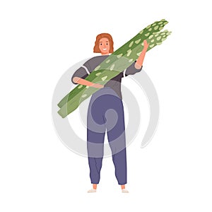 Tiny person holding big green asparagus stalks. Woman with healthy organic fresh vegetable in hands. Farmer carrying