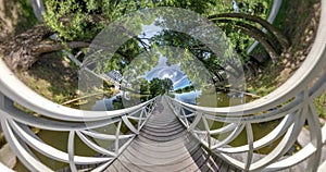 Tiny planet Transformation with curvature of space. Abstract torsion and spinning of full flyby panorama on wooden bridge in fores