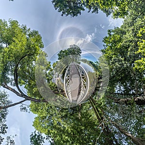 Tiny planet transformation of spherical panorama 360 degrees. Spherical abstract aerial view in forest near lake. Curvature of