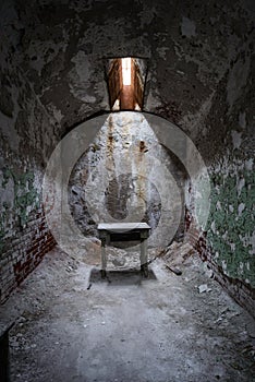 Tiny stool in an abandoned prison cell